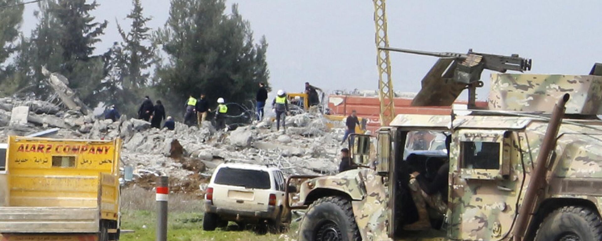 Un vehículo del Ejército libanés bloquea una carretera que conduce a un almacén destruido, al fondo, que fue atacado por la aviación israelí, bastión de Hezbolá, Líbano, el 26 de febrero de 2024  - Sputnik Mundo, 1920, 26.02.2024