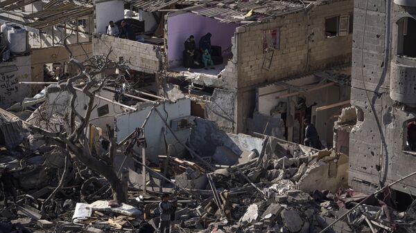 Palestinos observando la destrucción tras un ataque israelí contra edificios residenciales y una mezquita en Rafah, Franja de Gaza, el 22 de febrero, 2024 - Sputnik Mundo