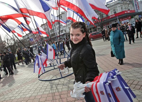 El 6 de marzo, el parlamento de Crimea decidió celebrar un referéndum sobre la unificación con Rusia. En la imagen: un reparto de banderas en la plaza de Simferópol durante el referéndum sobre el estatus de Crimea. - Sputnik Mundo