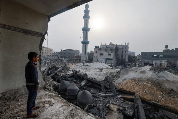 Un niño, en el interior de un edificio dañado, observa la mezquita de Al Faruq, arrasada por los bombardeos israelíes en Rafah, en el sur de la Franja de Gaza. - Sputnik Mundo