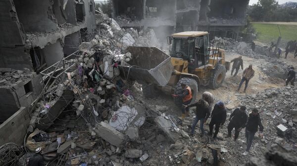 Palestinos buscan supervivientes tras un ataque aéreo israelí contra un edificio residencial en Gaza, el 23 de febrero, 2024 - Sputnik Mundo