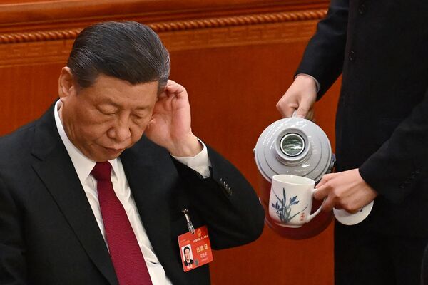 El mandatario chino gesticula mientras un asistente llena una taza de té durante la sesión de apertura de la Asamblea Popular Nacional. - Sputnik Mundo
