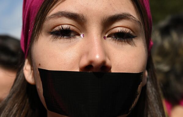 Una joven con la boca tapada con cinta aislante negra protesta contra la violencia de género en Roma, Italia. - Sputnik Mundo