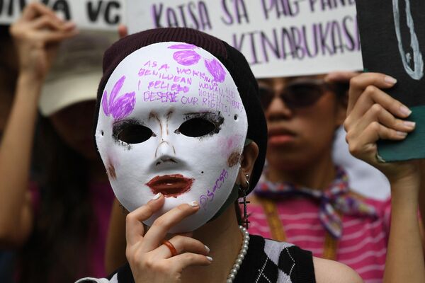 Una joven lleva una máscara con eslóganes durante una movilización del Día Internacional de la Mujer en Manila, Filipinas. - Sputnik Mundo