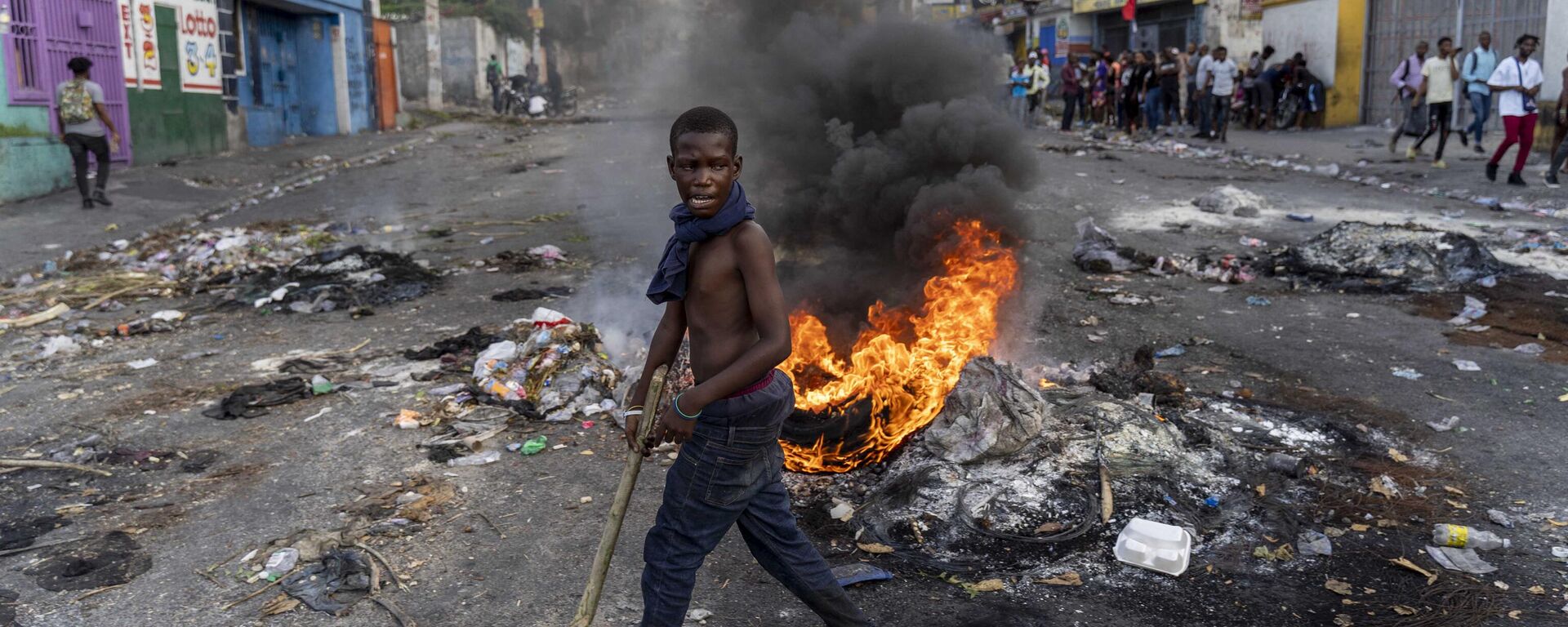 Un hombre camina entre barricadas en la capital de Haití, Puerto Príncipe, en medio de la violencia que azota al país - Sputnik Mundo, 1920, 13.03.2024