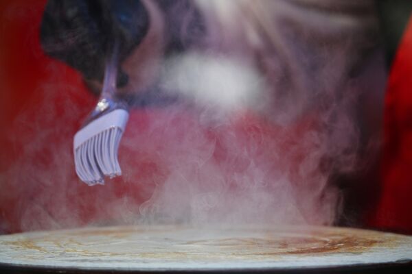 Preparación de crepes durante el festival &#x27;La Máslenitsa de Moscú&#x27;. - Sputnik Mundo