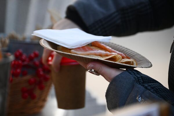 Una joven compra crepes en el festival de la &#x27;Máslenitsa de Moscú&#x27;, en la Plaza de la Revolución en Moscú. - Sputnik Mundo
