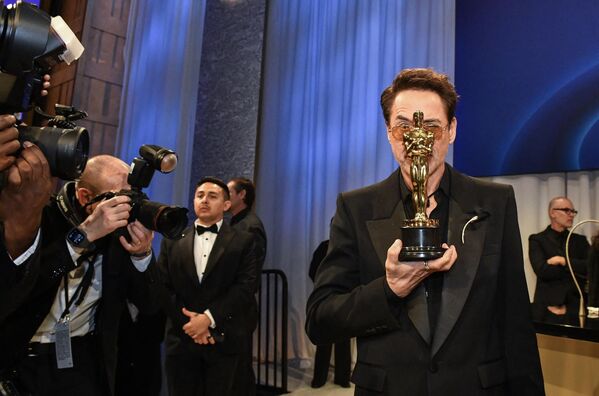 Fotógrafos tomando fotos del actor estadounidense Robert Downey Jr. mientras sostiene el Oscar al mejor actor de reparto. - Sputnik Mundo