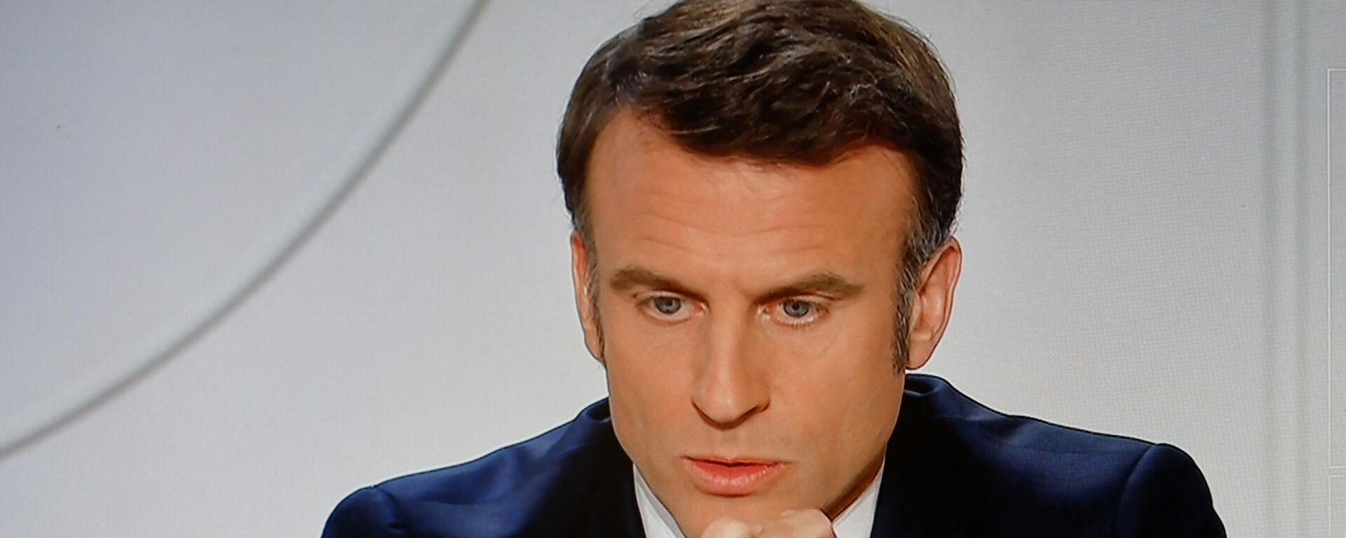 Una pantalla de televisión que emite al presidente de Francia, Emmanuel Macron, dirigiéndose a una entrevista en directo en los canales de televisión franceses 'TF1' y 'France 2' en el Palacio Presidencial del Elíseo en París - Sputnik Mundo, 1920, 26.03.2024