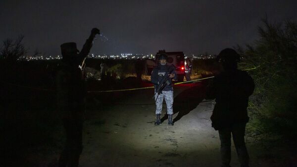 Miembros del Ejército mexicano vigilan la zona en la que se encontró un vehículo calcinado y unos 10 cuerpos carbonizados - Sputnik Mundo