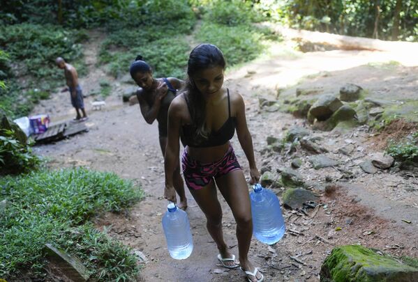Una joven llevando botellas de agua potable en Río de Janeiro, Brasil. - Sputnik Mundo