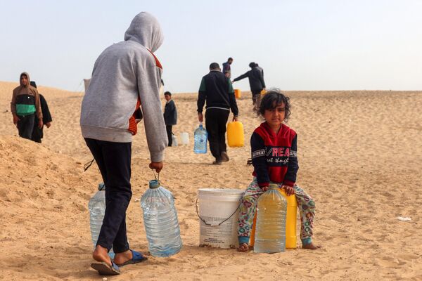 Según la ONU, 1,4 millones de personas mueren cada año debido a la mala calidad del agua, el saneamiento y la higiene. Una de cada cuatro personas —dos mil millones en todo el mundo— carece de agua potable.En la foto: palestinos reparten agua en el campo de refugiados de Rafah, en el sur de la Franja de Gaza, Palestina. - Sputnik Mundo