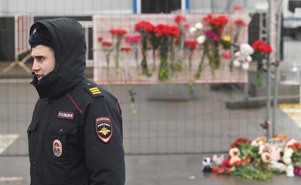 En toda Rusia se están organizando concentraciones en recuerdo de los fallecidos en el atentado terrorista. También se están llevando flores a la embajada rusa en distintos países.En la foto: un agente de policía delante de la sala de conciertos donde se produjeron los trágicos acontecimientos. - Sputnik Mundo
