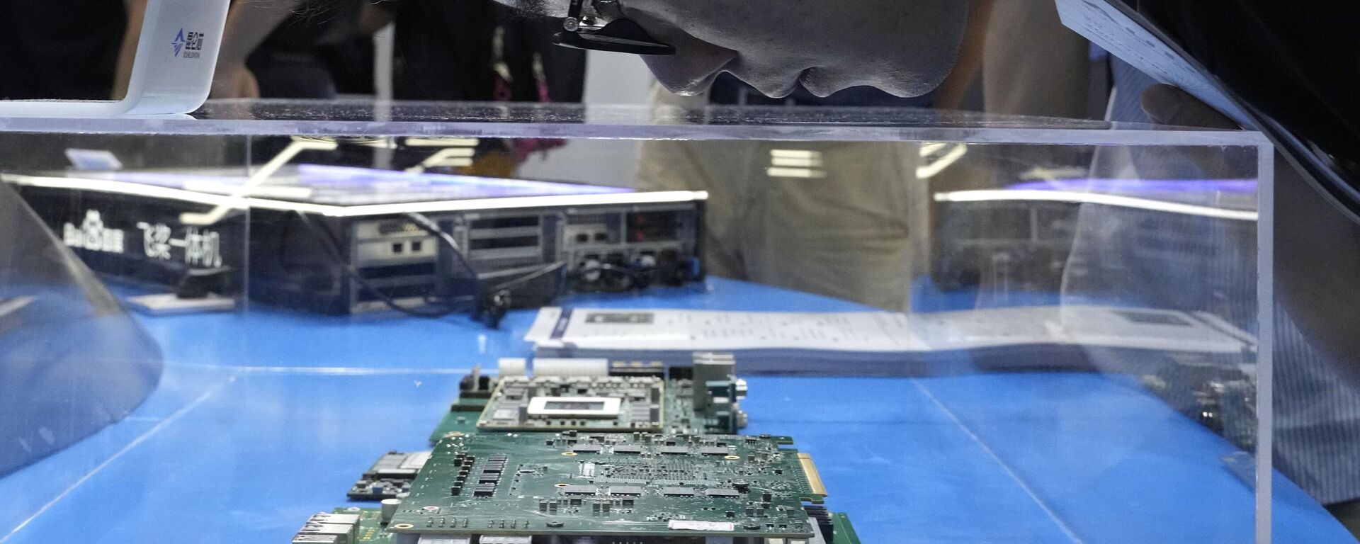 Un visitante examina un chipset de ordenador en el stand del desarrollador chino de semiconductores y chips Kunlunxin durante la Conferencia Mundial de Inteligencia Artificial en Shanghái, el 5 de julio de 2023  - Sputnik Mundo, 1920, 26.03.2024