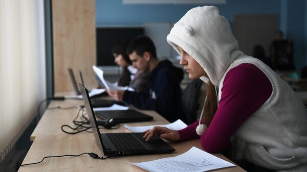Alumnos estudian con portátiles en un aula de una escuela - Sputnik Mundo