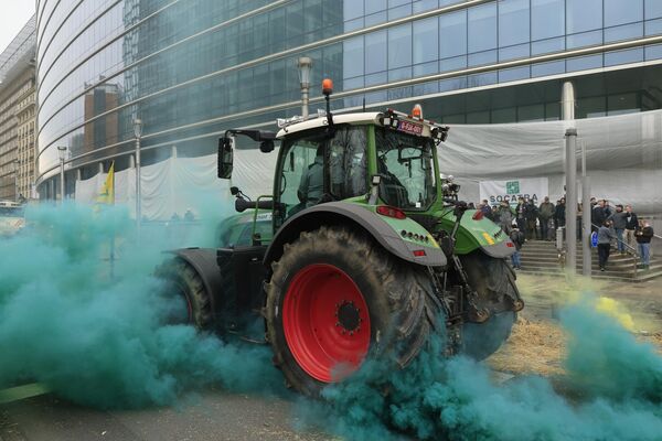 Un agricultor conduce su tractor cerca del edificio del Consejo Europeo en Bruselas. - Sputnik Mundo