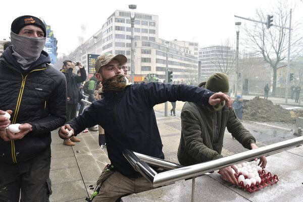 Cuando las protestas se convirtieron en enfrentamientos, la policía utilizó gases lacrimógenos y cañones de agua.En la foto: activistas lanzan huevos a la policía. - Sputnik Mundo