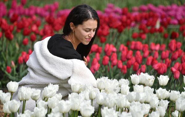 En la foto: una mujer en el jardín botánico Nikitski de Yalta, donde se celebra el 17.º Festival de tulipanes. - Sputnik Mundo