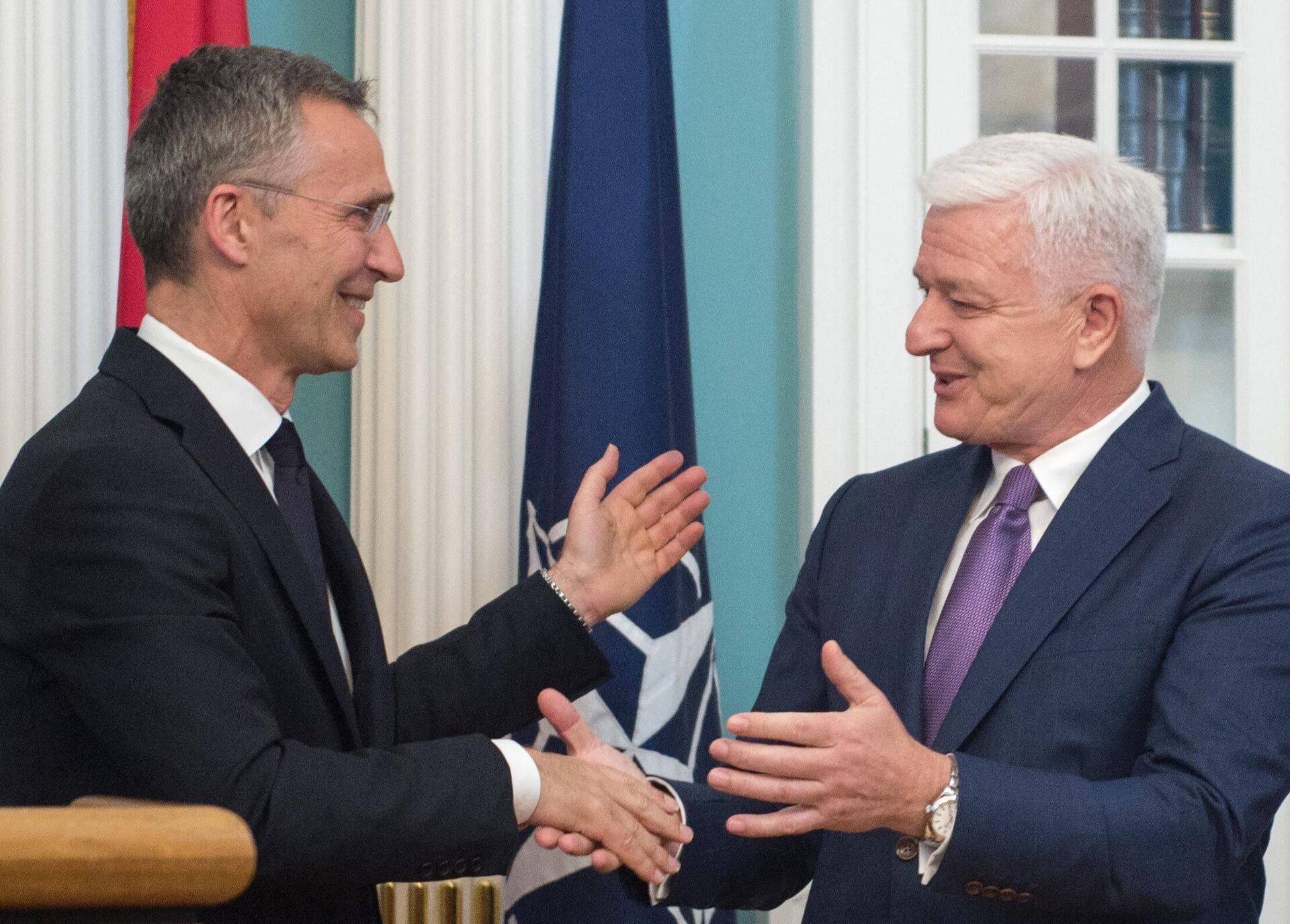 El secretario general de la OTAN, Jens Stoltenberg, y el primer ministro de Montenegro, Dusko Markovic, se felicitan mutuamente durante una ceremonia en Estados Unidos, el 5 de junio de 2017 - Sputnik Mundo, 1920, 29.03.2024