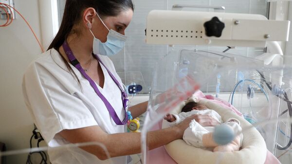 Una enfermera coloca a un recién nacido en una incubadora - Sputnik Mundo