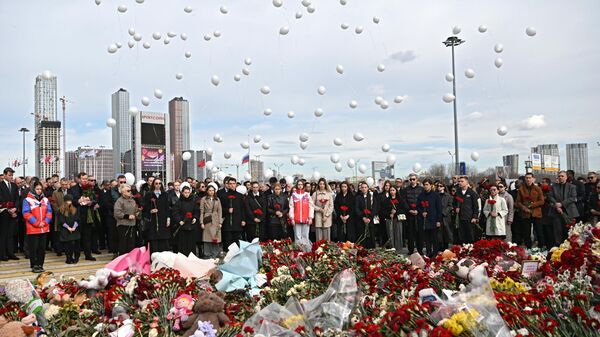 La gente coloca flores en el memorial frente al Crocus City Hall - Sputnik Mundo