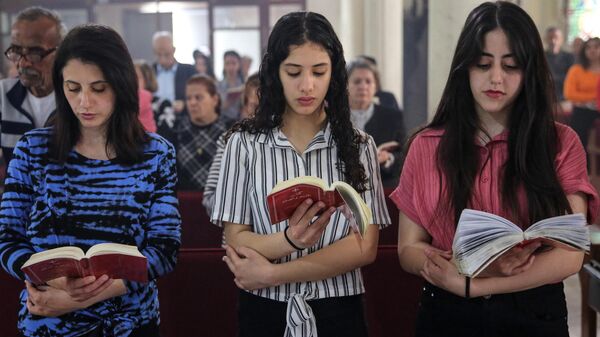 Cristianos palestinos celebran la misa del Domingo de Pascua en la iglesia católica de la Sagrada Familia de Gaza - Sputnik Mundo
