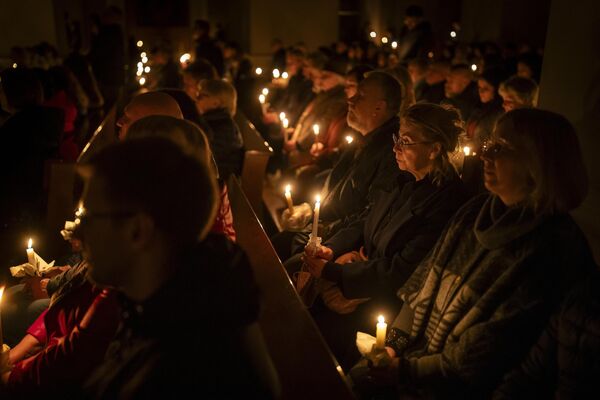 Los fieles colocan velas durante la misa celebrada en la noche de Pascua en la catedral basílica de Vilnius, Lituania. - Sputnik Mundo