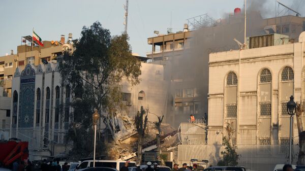 Los servicios de emergencia trabajan en un edificio destruido por un ataque aéreo en Damasco, Siria - Sputnik Mundo
