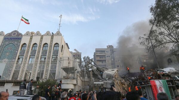 Personal de emergencia y de seguridad busca entre los escombros en el lugar de los ataques israelíes contra un edificio de  la embajada iraní en la capital de Siria, Damasco - Sputnik Mundo