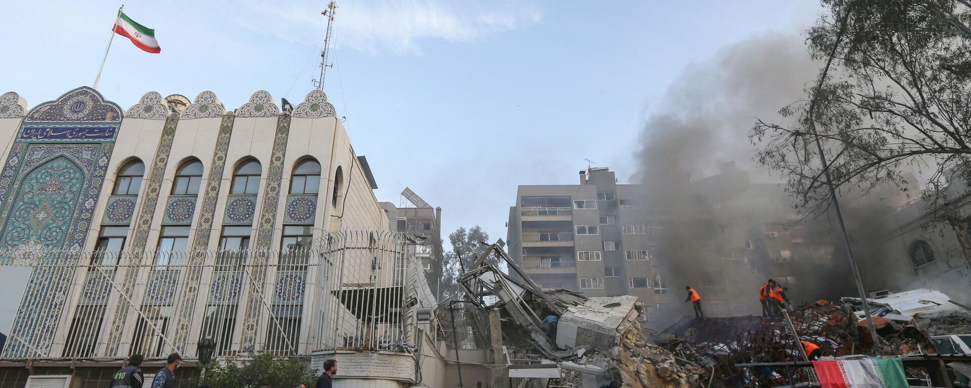 Personal de emergencia y de seguridad busca entre los escombros en el lugar de los ataques israelíes contra un edificio de  la embajada iraní en la capital de Siria, Damasco - Sputnik Mundo, 1920, 15.04.2024