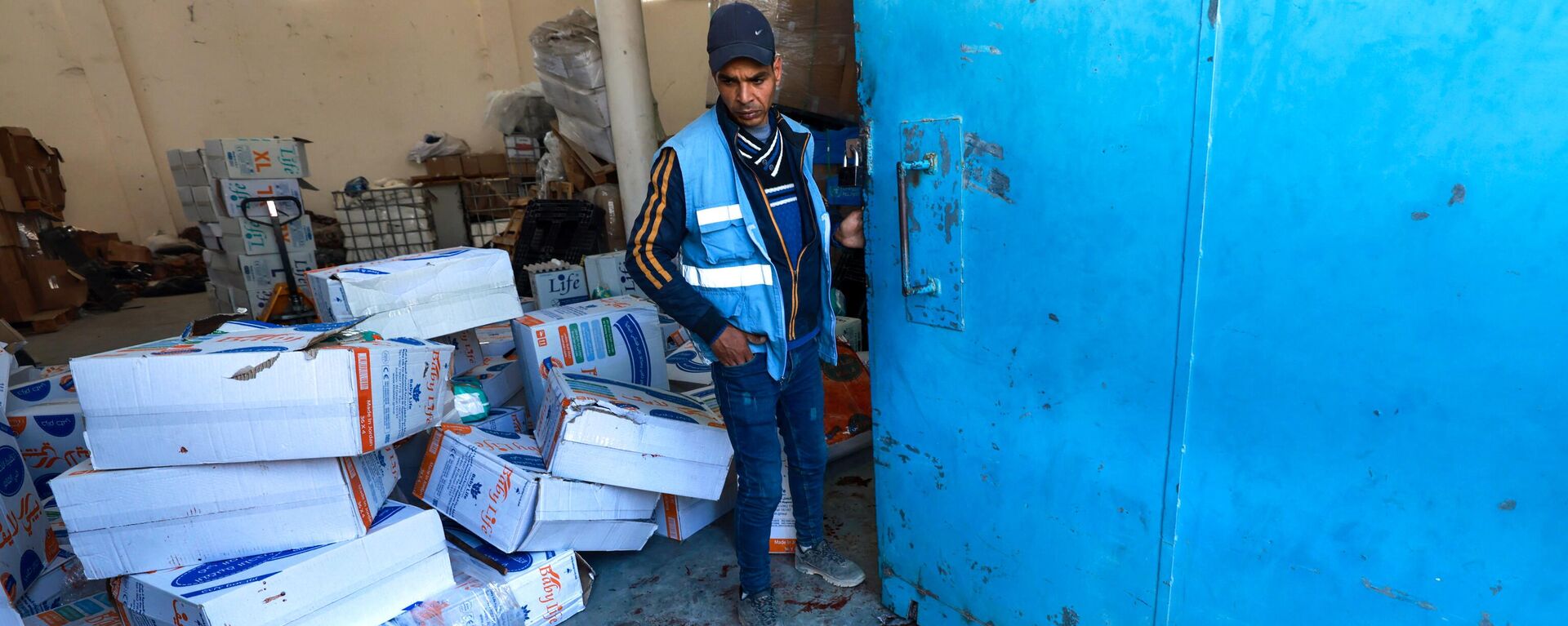 Un trabajador de la ONU cerca de un charco de sangre en un almacén y centro de distribución de la UNRWA en Rafah, en el sur de la Franja de Gaza, luego de un ataque israelí el 13 de marzo de 2024 - Sputnik Mundo, 1920, 02.04.2024