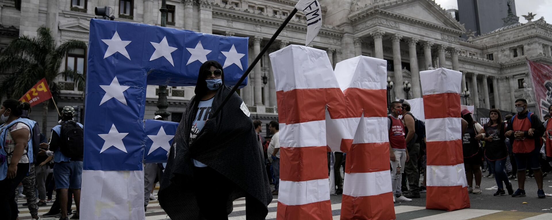 Un manifestante camina durante una protesta frente al Congreso argentino mientras los legisladores se preparan para votar una ley para ratificar el acuerdo del gobierno con el FMI para refinanciar unos 45.000 millones de dólares en deuda, en Buenos Aires - Sputnik Mundo, 1920, 04.04.2024
