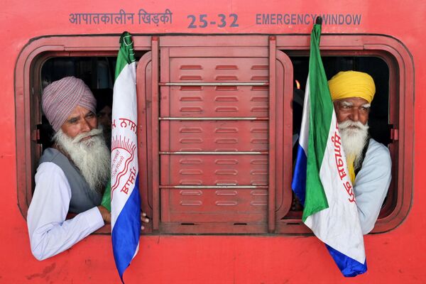 Agricultores se sientan en un tren para dirigirse a la frontera entre Haryana y Punjab, en la India, para manifestar su protesta y exigir precios mínimos para las cosechas. - Sputnik Mundo