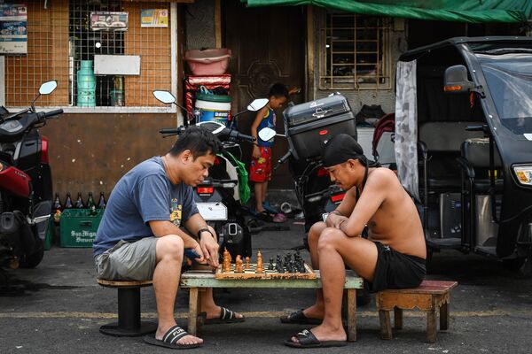 Hombres jugando al ajedrez en una calle de Manila, capital de Filipinas. - Sputnik Mundo