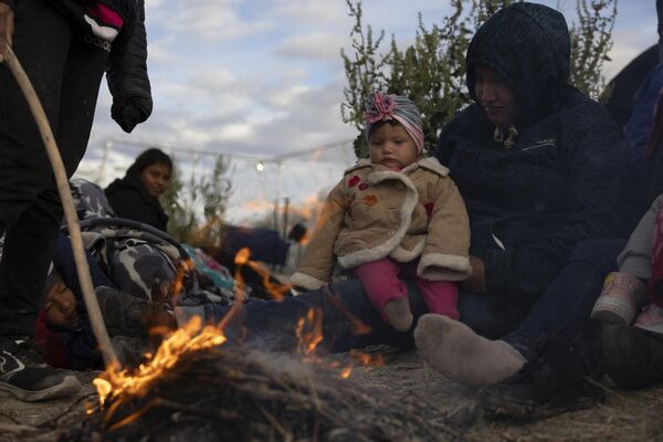 Migrantes venezolanos sentados alrededor de una hoguera improvisada mientras esperan asilo en El Paso, Texas, EEUU. - Sputnik Mundo