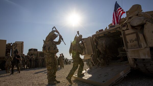 Tripulantes ingresan a vehículos de combate Bradley en una base militar estadounidense en un lugar no revelado en el noreste de Siria (archivo) - Sputnik Mundo