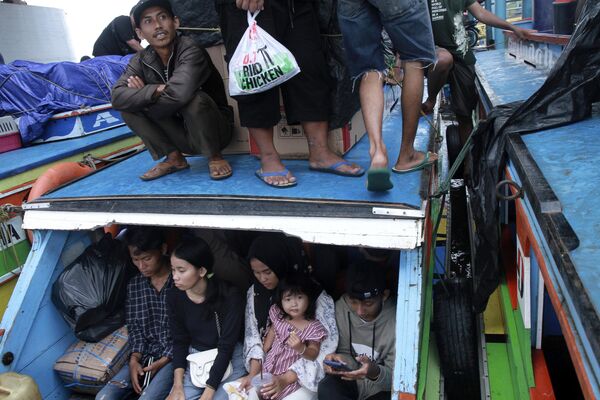 Personas suben a barcos para dirigirse a sus localidades de origen para celebrar la festividad de Eid al Fitr, en Indonesia. - Sputnik Mundo