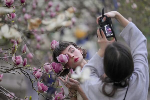 Unas jóvenes fotografían los árboles en flor en un parque de Kiev. - Sputnik Mundo