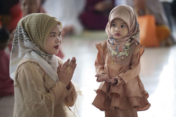 Mujer musulmana muestra a su hija cómo rezar al final del mes sagrado del Ramadán en la Mezquita Nacional en Kuala Lumpur, Malasia. - Sputnik Mundo
