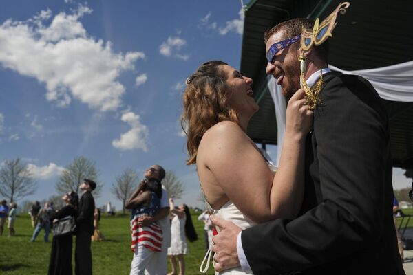 Recién casados durante un eclipse total del Sol, en Trenton, Ohio, EEUU. - Sputnik Mundo