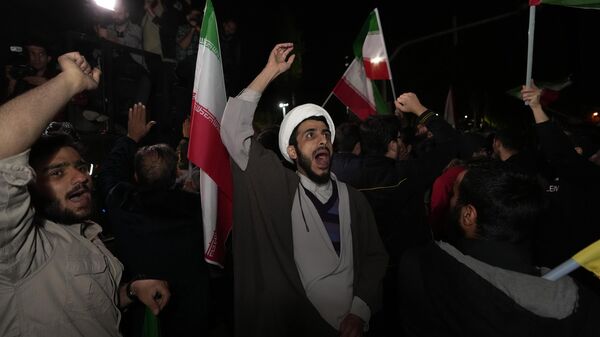 Manifestantes iraníes corean consignas durante su concentración antiisraelí frente a la Embajada británica en Teherán, el 14 de abril de 2024 - Sputnik Mundo
