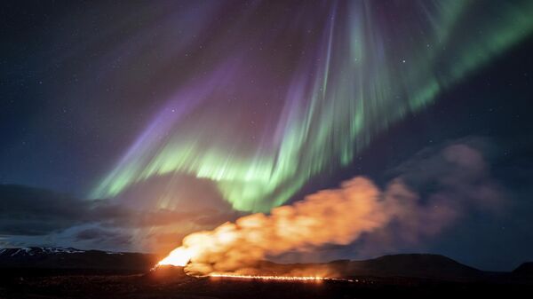 Вид на зону извержения вулкана на фоне северного сияния, Гриндавик, Исландия - Sputnik Mundo