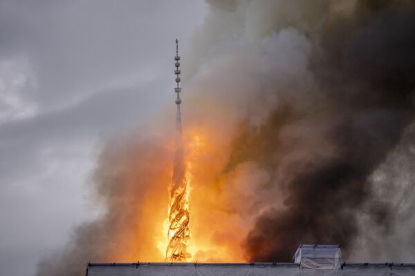 El humo se eleva por encima de la aguja en forma de dragón sobre el edificio de la Bolsa, en Dinamarca. - Sputnik Mundo