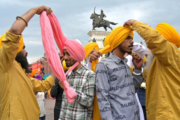 Sijíes se atan turbantes con motivo de la fiesta de la cosecha Vaisakhi en Amritsar, en la India. - Sputnik Mundo
