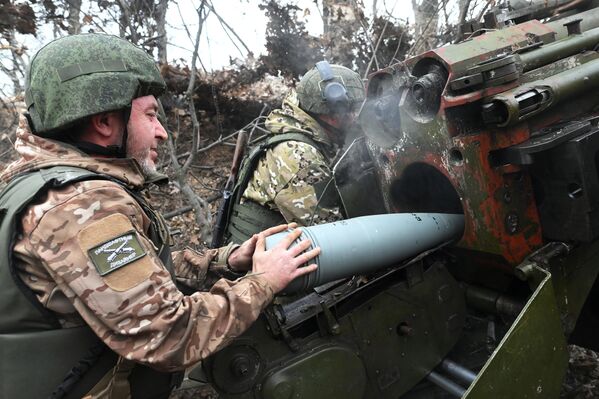 Militares del grupo de fuerzas Sur cargan un cañón de campaña 2A36 Giatsint-B para el trabajo de combate en la zona de la operación militar especial. - Sputnik Mundo