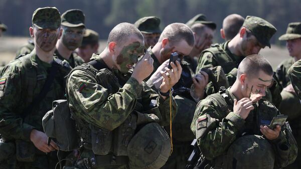 Miembros de la Brigada de Infantería Mecanizada Lobo de Hierro del Ejército de Lituania se aplican camuflaje en la cara durante el ejercicio militar en la base militar de Rukla, Lituania  - Sputnik Mundo