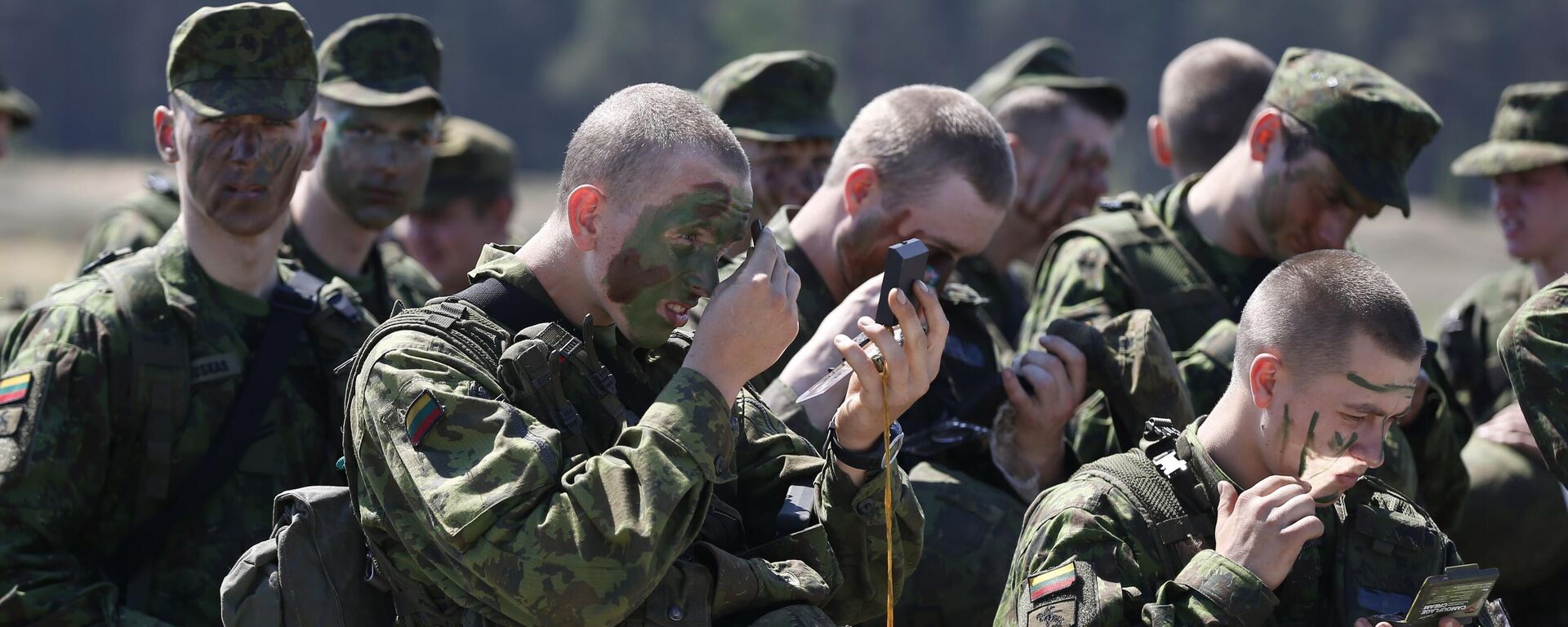 Miembros de la Brigada de Infantería Mecanizada Lobo de Hierro del Ejército de Lituania se aplican camuflaje en la cara durante el ejercicio militar en la base militar de Rukla, Lituania  - Sputnik Mundo, 1920, 21.04.2024