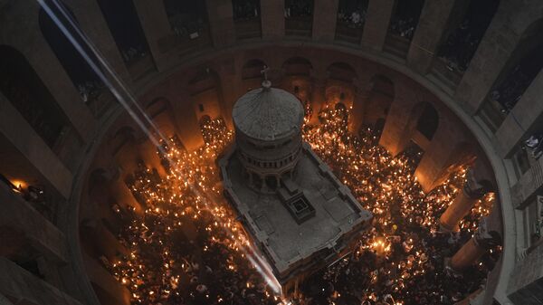 Peregrinos cristianos sostienen velas durante la ceremonia del Fuego Sagrado, un día antes de Pascua, en la Iglesia del Santo Sepulcro, el 15 de abril - Sputnik Mundo