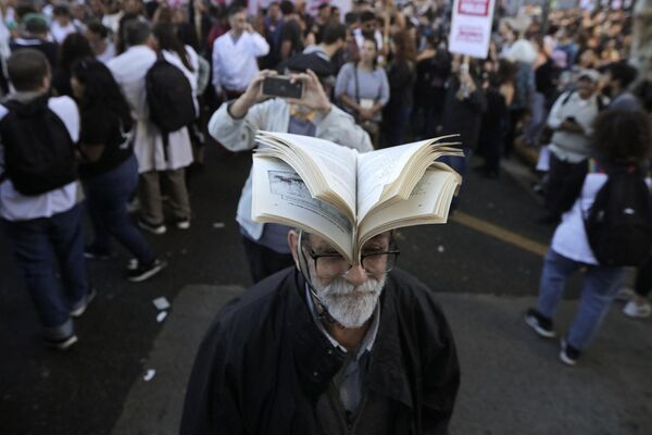 Un hombre lleva un libro en la cabeza durante una marcha en protesta por el ajuste presupuestario a las universidades públicas en la capital argentina,  Buenos Aires. - Sputnik Mundo