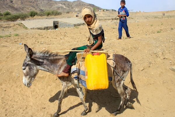 Un niño monta un burro hasta un depósito para recoger agua cerca de un campamento improvisado para yemeníes desplazados internos en provincia norteña de Hajjah. - Sputnik Mundo